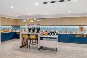 TownePlace Suites by Marriott Richmond Colonial Heights في كولونيل هايتس: مطبخ مع دواليب زرقاء وكاونتر مع الكراسي