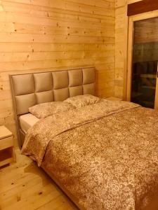 a bedroom with a bed in a wooden wall at Chalet Blanc in Kolašin