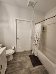 a white bathroom with a toilet and a shower at Modern 2 bed apt, mins to NYC! in Jersey City