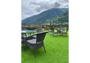 La Serene Valley Resort By DLS Hotels في مانالي: مجموعة طاولات وكراسي تجلس على العشب