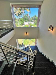 - un escalier dans une maison avec une grande fenêtre dans l'établissement BAVA Lalitha Retreat Center Varkala, à Varkala