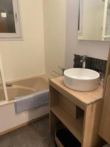 a bathroom with a sink and a tub at Appartement lumineux et cosy en rez de jardin in Saint-Gervais-les-Bains +4 photos