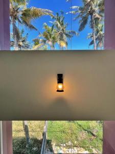 a light in a room with a window with palm trees at BAVA Lalitha Retreat Center Varkala in Varkala