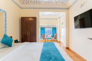 a bedroom with a large bed and a tv at Natural Lake View Hotel in Udaipur