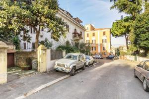 une voiture blanche garée sur le côté d'une rue dans l'établissement Apartment Il Giardino di Linda a San Pietro, à Rome