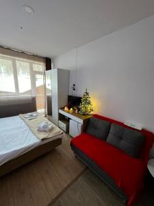 a bedroom with a red bed and a christmas tree at Apartment in Bakuriani in Bakuriani