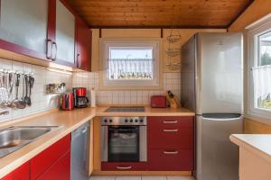a kitchen with red cabinets and a refrigerator at Nixe in Simonsberg +9 photos