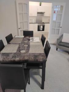 a dining room table with chairs and a kitchen at Modern 2 bed house sleeps 6 in Portsmouth