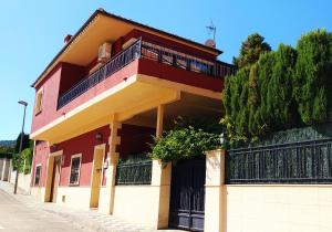 a red building with a balcony on a street at Casa Axier-Chalet con Piscina privada y chimenea in Biar
