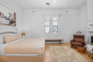 een witte slaapkamer met een bed en een stoel bij Wanderlust Cottage Grange in Grange
