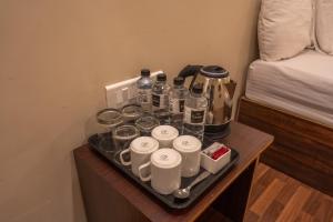 a tray with cups and drinks on a table next to a bed at marron sea view resort in Palolem