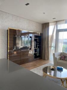 a living room with a television and a table at Modern 2BR and maid room with big terrace city walk in Dubai