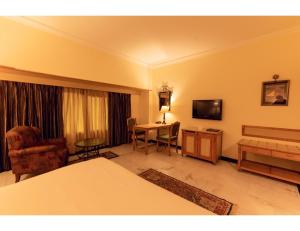 een hotelkamer met een bed en een bureau bij A Hotel, Ludhiana in Ludhiana