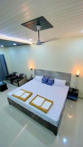 a bedroom with a large bed and a living room at Ashoka Lawns and Resort in Alibaug