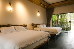 a bedroom with two beds and a balcony at Tổ Boutique Garden in La Gi