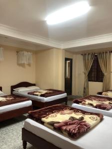 a room with four beds in a room at Nhat Quynh Hotel in Da Lat