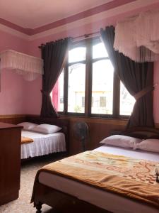 a bedroom with two beds and a window at Nhat Quynh Hotel in Da Lat