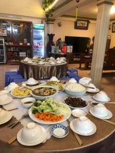 a table with plates of food and bowls of food at Nhat Quynh Hotel in Da Lat