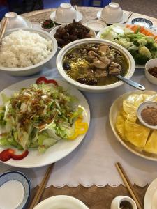 a table with plates of food and bowls of food at Nhat Quynh Hotel in Da Lat