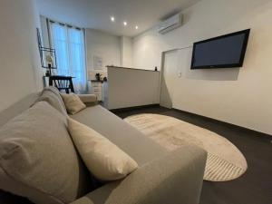 a living room with a couch and a flat screen tv at Charmant Studio - Port de Nice in Nice