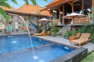 a pool with a water fountain in front of a house at Taman Prabhawa in Sukawati