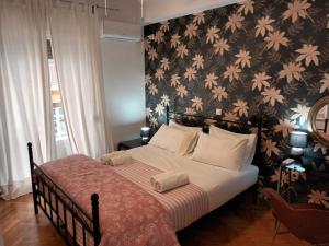 a bedroom with a bed with a floral wallpaper at Stunning apartment in the heart of Athens in Athens