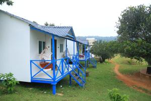 a blue and white house with a staircase next to it at Rainbow Residency in Yelagiri