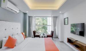 a bedroom with a bed and a tv and a table at Okean De Goa Vagator in Vagator