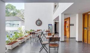 a restaurant with tables and chairs and a clock on the wall at Okean De Goa Vagator in Vagator
