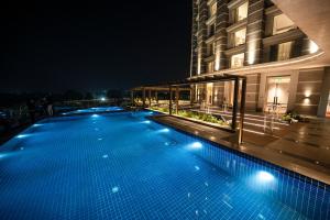 a swimming pool in front of a building at night at LYFE HOTEL in Bhubaneshwar