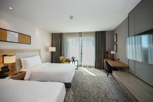 una camera d'albergo con due letti e una scrivania di LYFE HOTEL a Bhubaneshwar