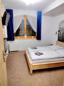 a bedroom with a bed and a window with blue curtains at Rezydencja Pod Giewontem in Zakopane