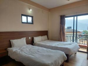 Cette chambre dispose de 2 lits et d'un balcon. dans l'établissement Hotel Lake Journey, à Pokhara
