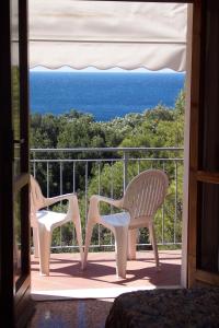 two chairs sitting on a balcony looking out at the ocean at Hotel Rosa Del Tirreno in Quercianella