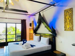 Un dormitorio con una cama con una cinta azul. en Boomerang Village Resort Kata, en Kata Beach