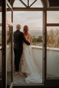 Una novia y un novio parados frente a una ventana en Landhotel Bellevue, en Wolfshausen