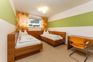 a room with two beds and a desk and a table at Appartementhaus Leeder by Schladming-Appartements in Schladming +5 photos