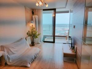 - un salon avec un lit et une grande fenêtre dans l'établissement Goseong Ayajin Perfect oceanview holiday sunset house, à Goseong