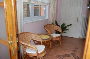 three wicker chairs and a table and a window at Guest house Hošek in Senorady