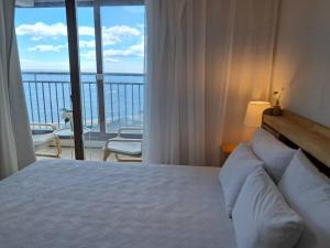a bedroom with a bed with a view of a balcony at Goseong Ayajin Perfect oceanview holiday sunset house in Goseong