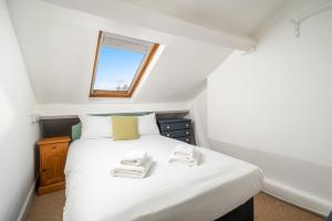 um quarto com uma cama branca e uma janela em ALTIDO Cosy maisonette near Abbey Road em Londres