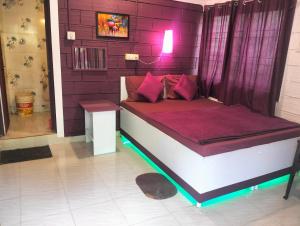 uma cama num quarto com uma parede roxa em Greenland gokarna Ac and Non Ac em Gokarna