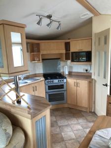 a kitchen with wooden cabinets and a stove at No 70 in Newton Stewart