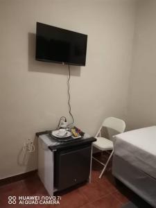 Zimmer mit einem Bett und einem TV an der Wand in der Unterkunft Fabulous Rest Inn in Francistown