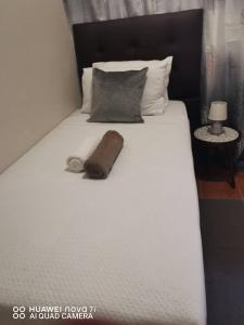a large white bed with a brown towel on it at Fabulous Rest Inn in Francistown