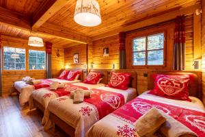 sypialnia z 3 łóżkami w drewnianym domku w obiekcie L'Écrin des Pyrénées - Authentique chalet classé 4 étoiles avec jacuzzi w mieście Font-Romeu-Odeillo-Via