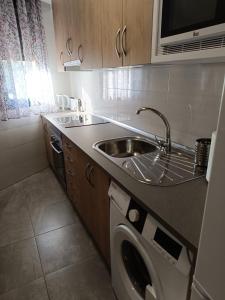 a kitchen with a sink and a washing machine at EL BOSQUE 1 - Parking gratis in Toledo