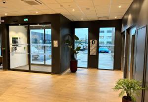 een kantoorlobby met een deur met een potplant bij B&B HOTEL Cergy Saint-Christophe Gare in Cergy