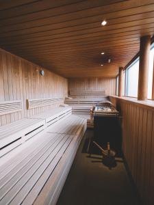 una sauna con suelos y bancos de madera y una ventana en Walch's Rote Wand Gourmethotel, en Lech am Arlberg