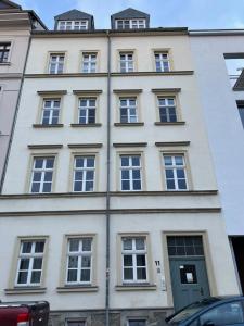 - un bâtiment blanc avec de nombreuses fenêtres dans l'établissement Das City-Appartment Zentrum West, à Leipzig
